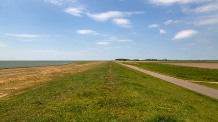 Obraz premium Typical rural landscape with dike of southwestern part of Dutch province Friesland