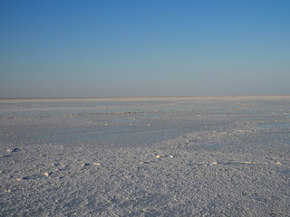 white surface of the lake covered with salt at sunrise