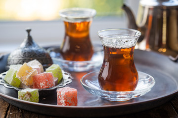 Glass Cup of turkish tea served in traditional style with summer outdore view
