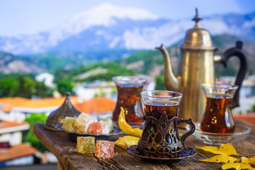 Glass Cup of turkish tea served in traditional style with summer outdore view