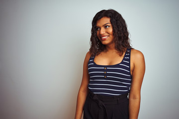 Transsexual transgender woman wearing striped t-shirt over isolated white background looking away to side with smile on face, natural expression. Laughing confident.