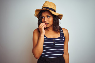 Beautiful transsexual transgender woman wearing summer hat over isolated white background looking stressed and nervous with hands on mouth biting nails. Anxiety problem.