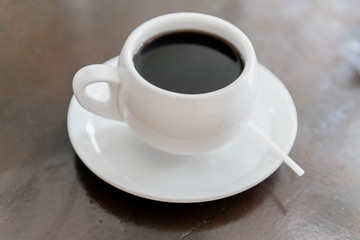 Tada with coffee, white color in small plate on the table.