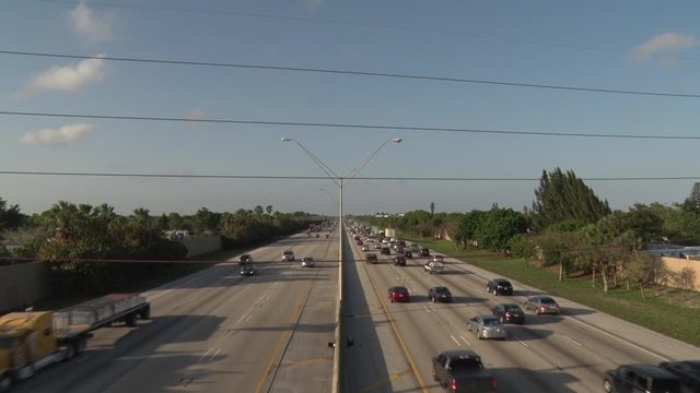 I-95 Facing North through Three Power Lines in Deerfield Beach in a Bright Sunny Late Afternoon in Rush Hour Traffic, Blue Sky with a Few Scattered Clouds