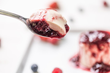 Delicious italian dessert panna cotta with berry sauce, fresh berries on white wooden background