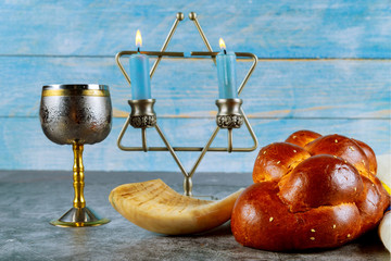 Shabbat challah bread, shabbat wine and candles on the table. Top view