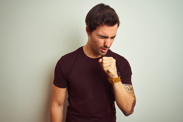 Young handsome man with tattoo wearing purple casual t-shirt over isolated white background feeling...