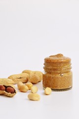 Peanut butter and peanuts isolated on white background