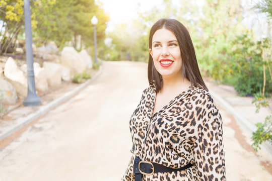 Young beautiful woman with red lips smiling happy at garden
