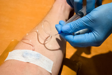 Doctor gives an intravenous injection to a patient in a hospital