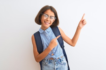 Beautiful student child girl wearing backpack and glasses over isolated white background smiling and looking at the camera pointing with two hands and fingers to the side.