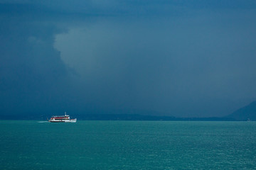 Lake Garda, Italy - August 13 2019. The view from the top to Lake Garda is fabulous. A gloomy sky awaiting a thunderstorm. Ship, boat, freshness, rain.