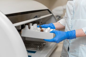 Laboratory technician test blood in automatic blood sample analyzer.