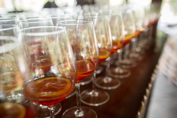 A lot of cocktails at the bar at the wedding party. Glasses with apperol and with a slice of lemon close up