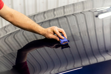 Car Detailing - A man is applying a nanoprotective coating to a car. A professional ceramic stacker applies different layers to the machine with an applicator sponge. Concept from: Auto Detailing