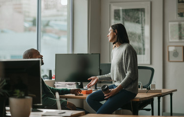 Designer talking with a male coworker during an office break