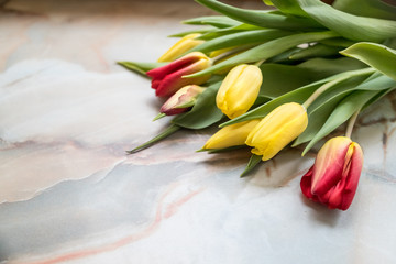 Beautiful tulips for Mother's Day on marble background, side view.International Women's Day.Bouquet of beautiful spring tulips. Fresh colorful tulip flowers on stone table.