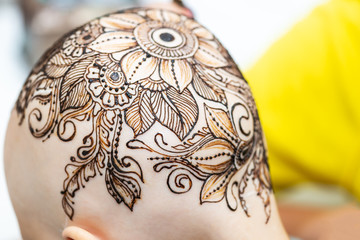 Drawing process of henna mehndi ornament on womans head