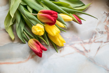Obraz premium Beautiful tulips for Mother's Day on marble background, side view.International Women's Day.Bouquet of beautiful spring tulips. Fresh colorful tulip flowers on stone table.