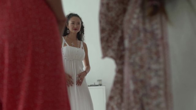 Attractive asian girl in white dress with long curly black hair dancing during spiritual female practice