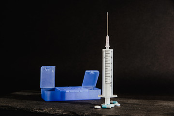 Medications, tablets are on a dark, black countertop. Medical and pharmaceutical concept. Help in taking medicine, regularity. Drug abuse.