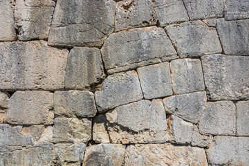 The ancient megalithic walls surround the acropolis of Amelia, in Umbria, Italy. Texture composed of huge blocks of stone, with irregular boulders interlocked together.