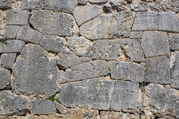 The ancient megalithic walls surround the acropolis of Amelia, in Umbria, Italy. Texture composed of huge blocks of stone, with irregular boulders interlocked together.