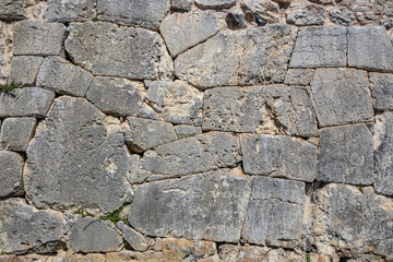 The ancient megalithic walls surround the acropolis of Amelia, in Umbria, Italy. Texture composed of huge blocks of stone, with irregular boulders interlocked together.