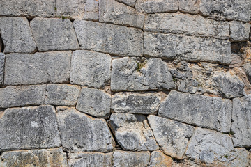 The ancient megalithic walls surround the acropolis of Amelia, in Umbria, Italy. Texture composed of huge blocks of stone, with irregular boulders interlocked together.