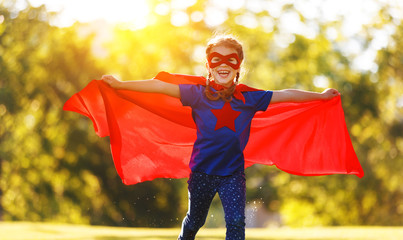 concept happy child superhero hero in red cloak  in nature. © JenkoAtaman