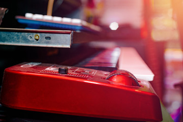 Electric Piano. Record sound, music. Making music, recording. Creating sound foundations. Red electric keyboard on the red background in the recording room.