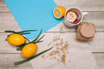 natural medicine, aloe, chamomile, tea with lemon, crawled nuts and seeds on a gray blue background, copy space, lemons, tea leaves