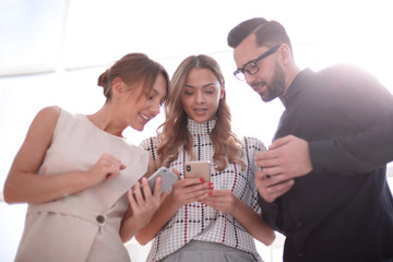 business team looking at the screens of their smartphones