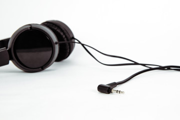 Black headphones isolated on white. The concept of creating and listening to music. Comfortable headphones for listening to music. Creating sounds and listening to the foundations.
