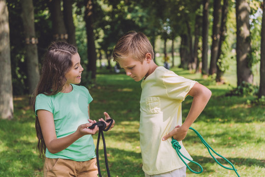 happy kid holding rope with sea knot near friend