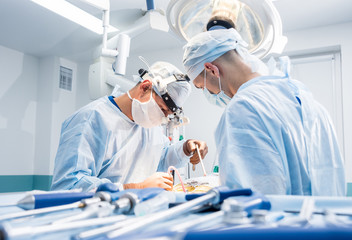 Spinal surgery. Group of surgeons in operating room with surgery equipment. Laminectomy