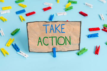Handwriting text writing Take Action. Conceptual photo to do somethingoract in order to get a particular result Colored clothespin papers empty reminder blue floor background office pin