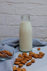 Non-dairy vegan almond milk in a jar on grey background