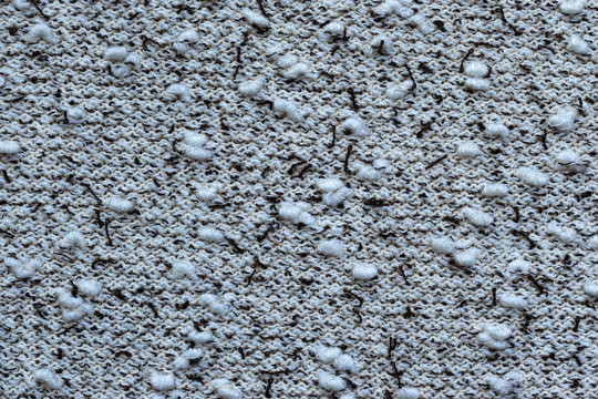 Background in the form of a knitwear with soft white boucle and dark brown veins on a light background