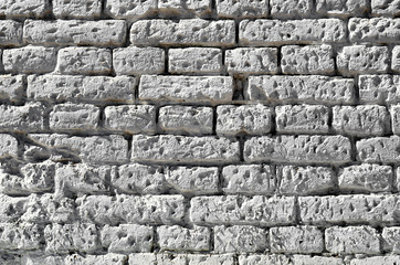 Texture of an old brick wall painted in white.