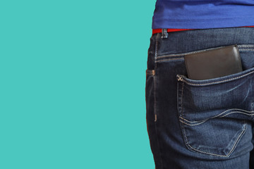 black wallet in the back pocket of blue jeans man isolated on green 