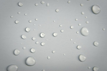 Large drops of water on a white surface.