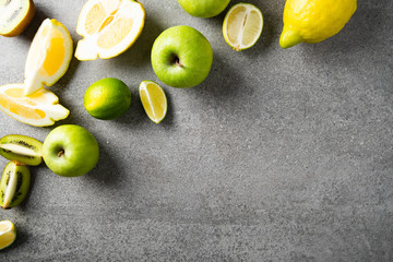 Fresh fruits on gray concrete background. Green and yellow healthy food, clean eating. Detox,...