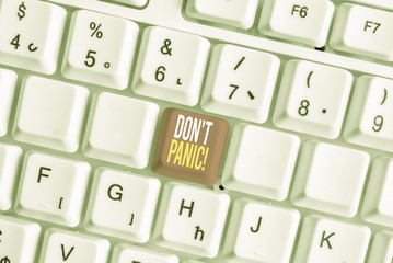 Word writing text Don T Panic. Business photo showcasing suddenly feel so worried or frightened that you can not behave White pc keyboard with empty note paper above white background key copy space