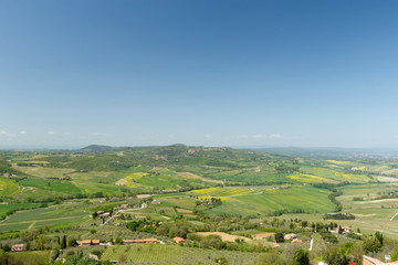 Fototapeta na wymiar Tuscan countryside with farms and green grass, as seen from above