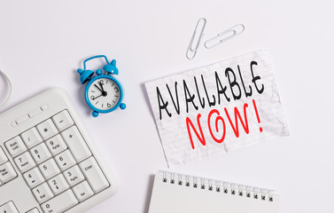 Writing note showing Available Now. Business concept for you can find it obtain or operable at this current moment Blank paper with copy space on the table with clock and pc keyboard