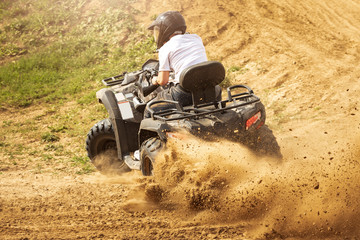 Quad bikes driving in the sand .