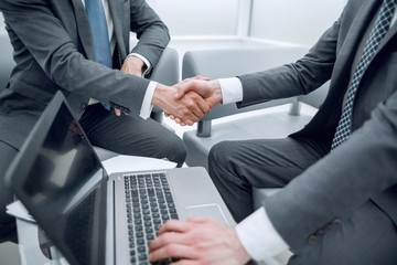 close up.the financial partners shaking hands over a Desk