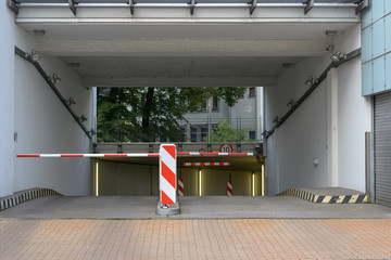 entrance and exit driveway with barrier to a underground parking garage