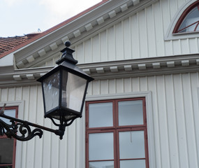 An antique lantern in the background of a white house. Orebro old town. Travel photo